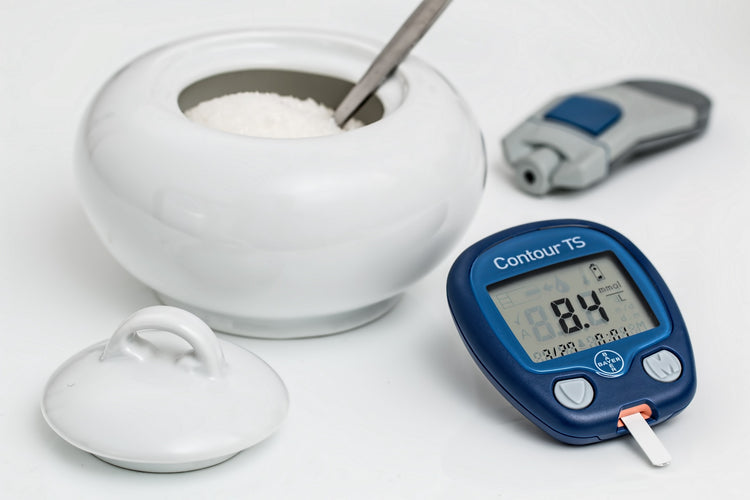 blood sugar monitor and a bowl of sugar